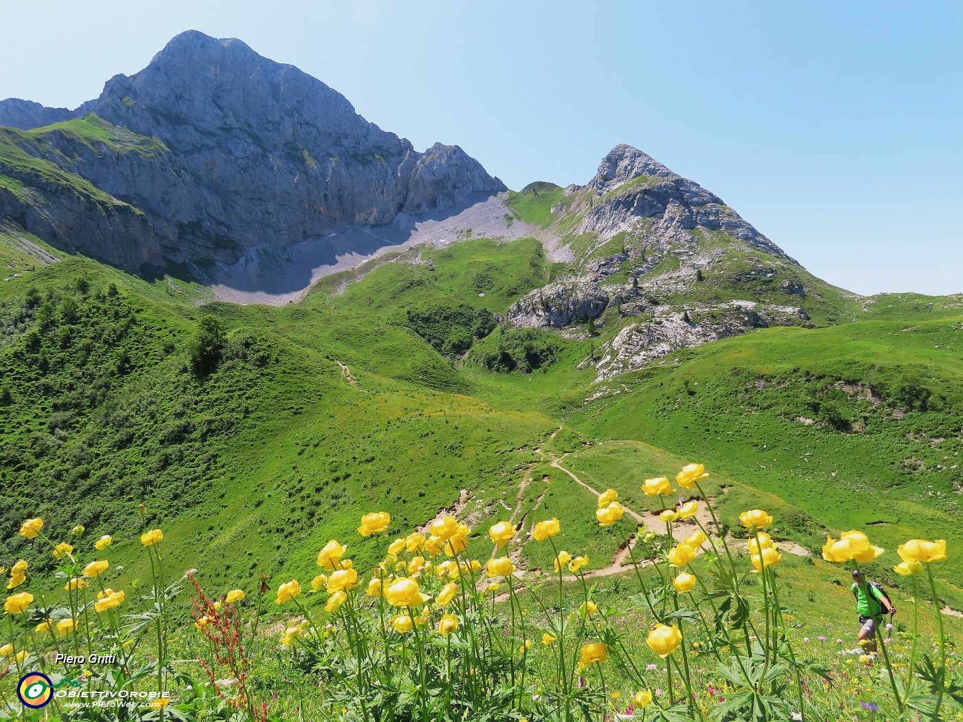 49 Su pratoni fioriti con vista in Corna Piana scendiamo al Passo Branchino.JPG